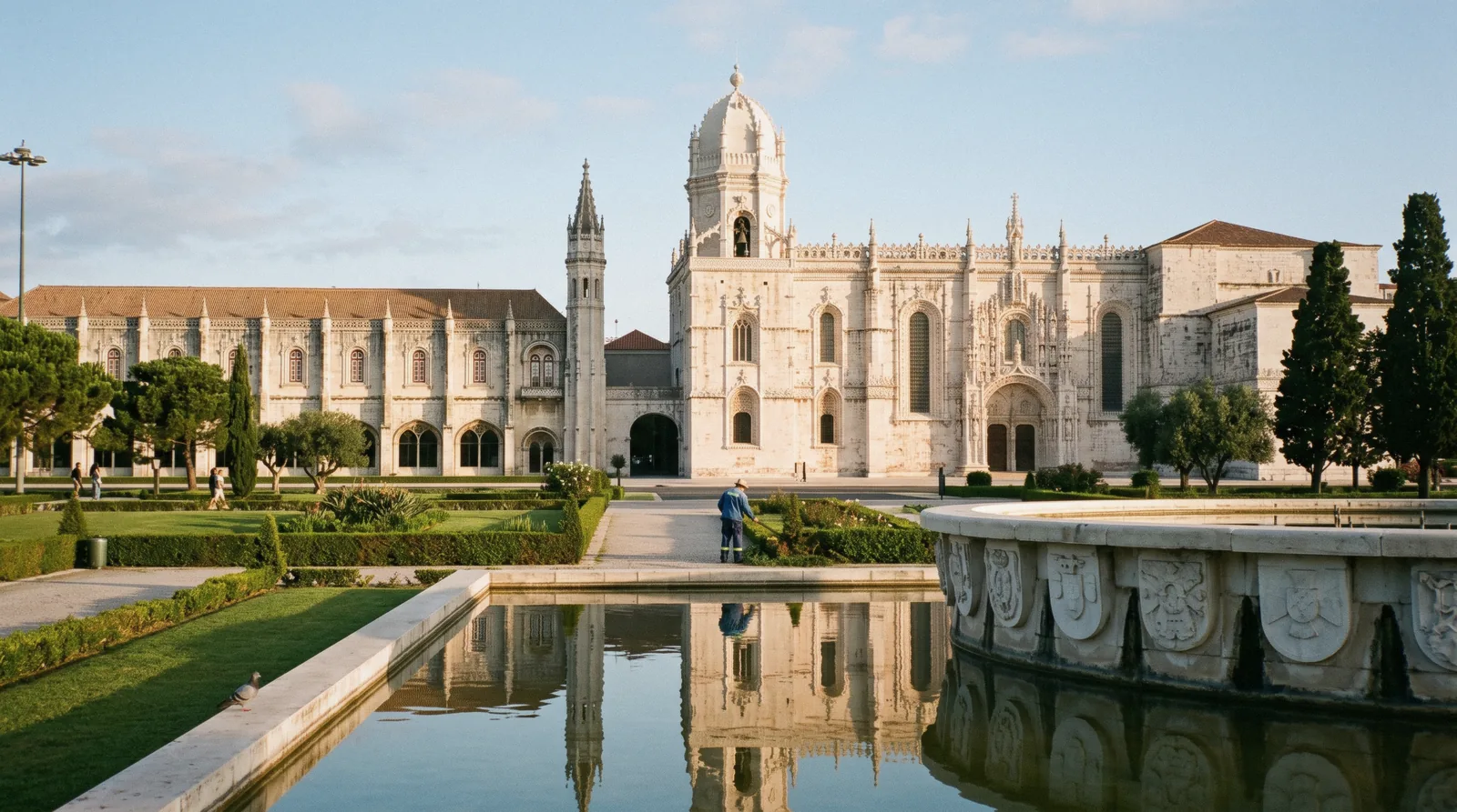 The south portal and long limestone façade of the Jerónimos Monastery at 09:20 with the Praça do Império fountain in front, Jerónimos Monastery Lisbon