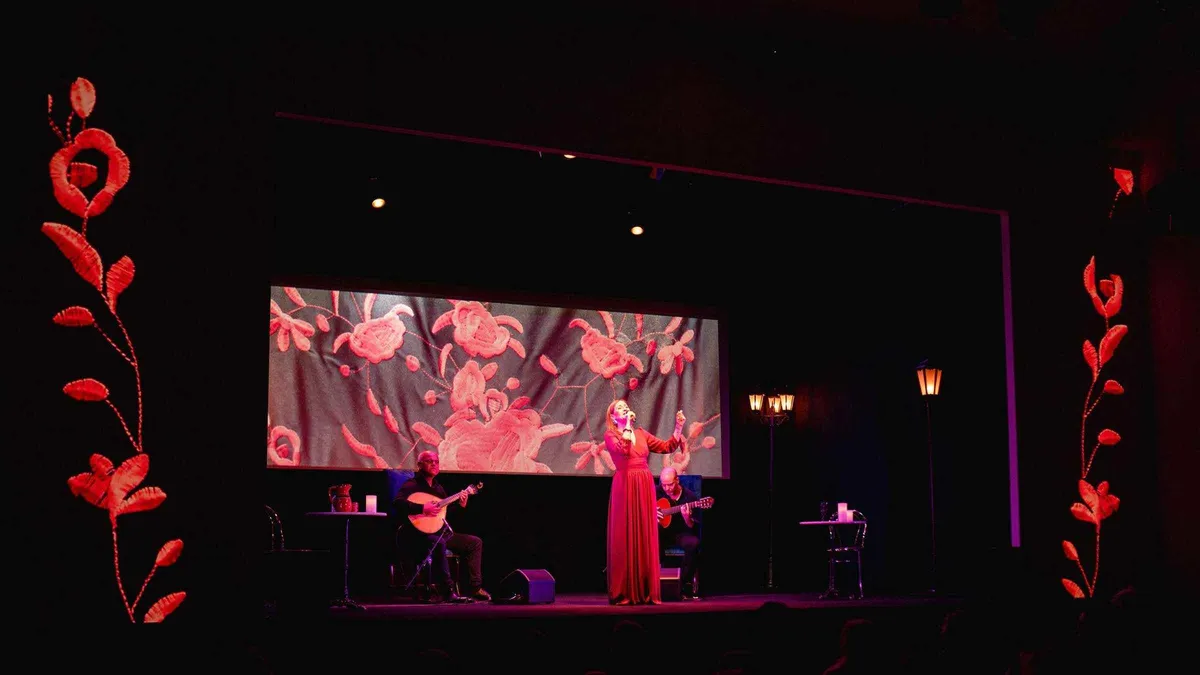 Singer performing under projected images of Lisbon at the Fado in Chiado live show