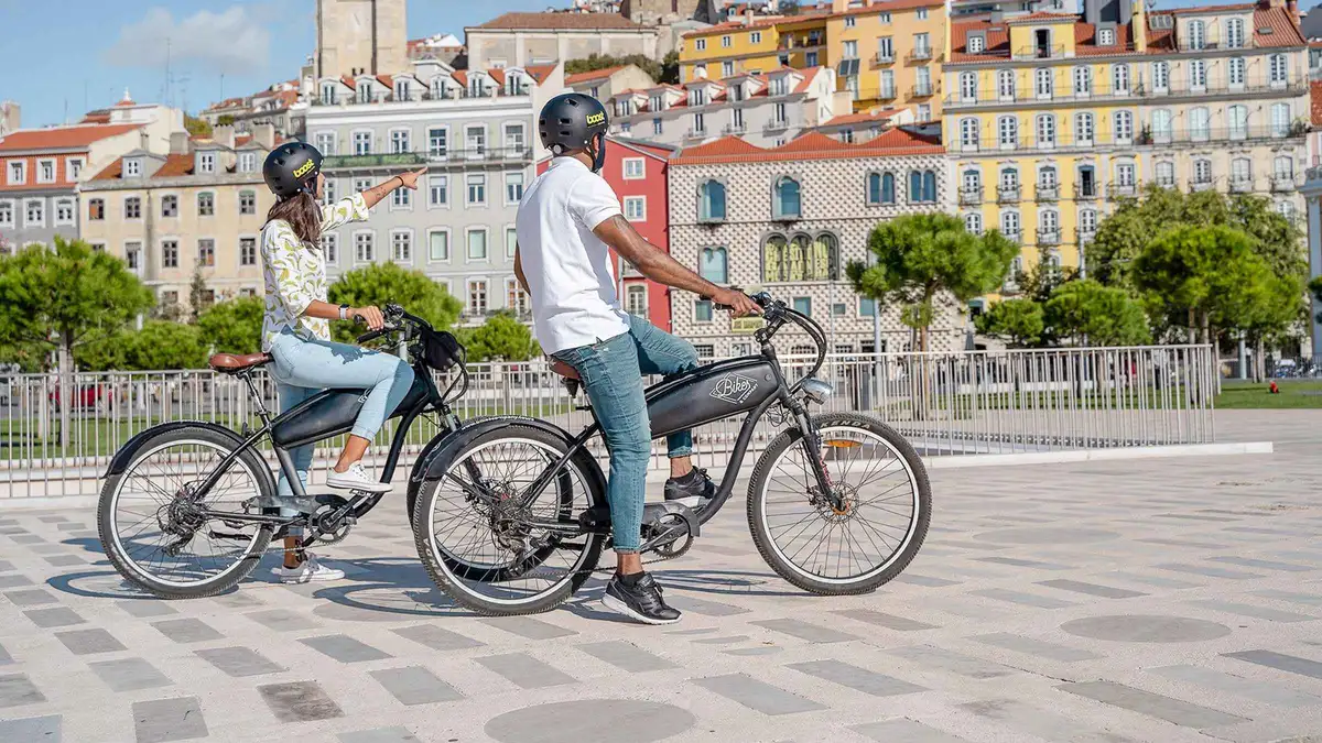 E-bike riders pausing at a Graça viewpoint on a Hills, Alfama and Mouraria electric bike tour in Lisbon