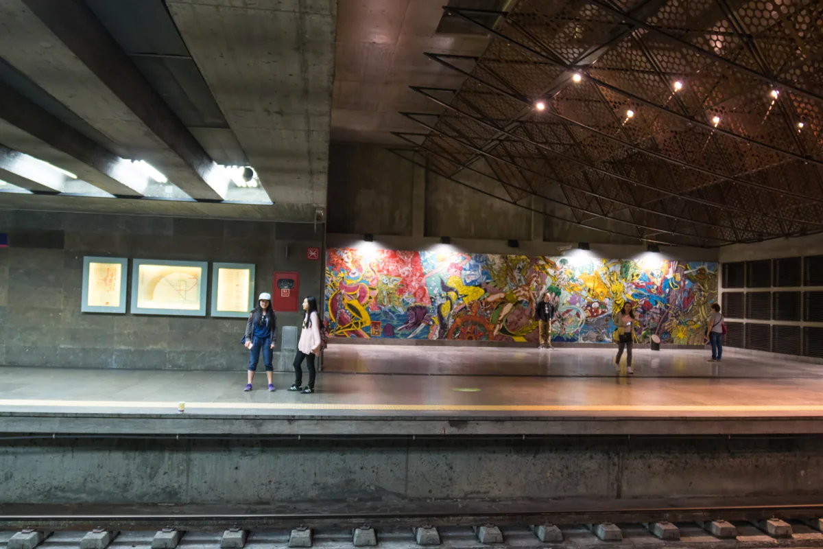The platform of Oriente metro station on the red line, passengers waiting beside the painted mural